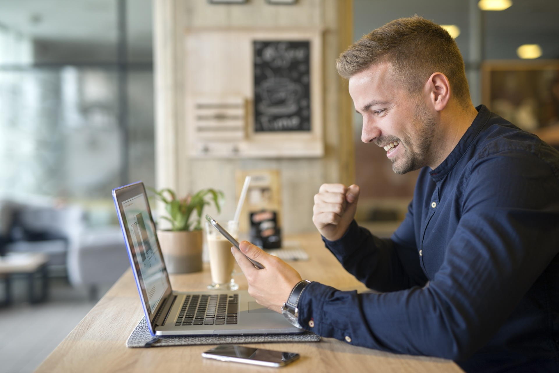 Happy freelancer with tablet and laptop computer in coffee shop. Happy freelancer with tablet and laptop computer in coffee shop.