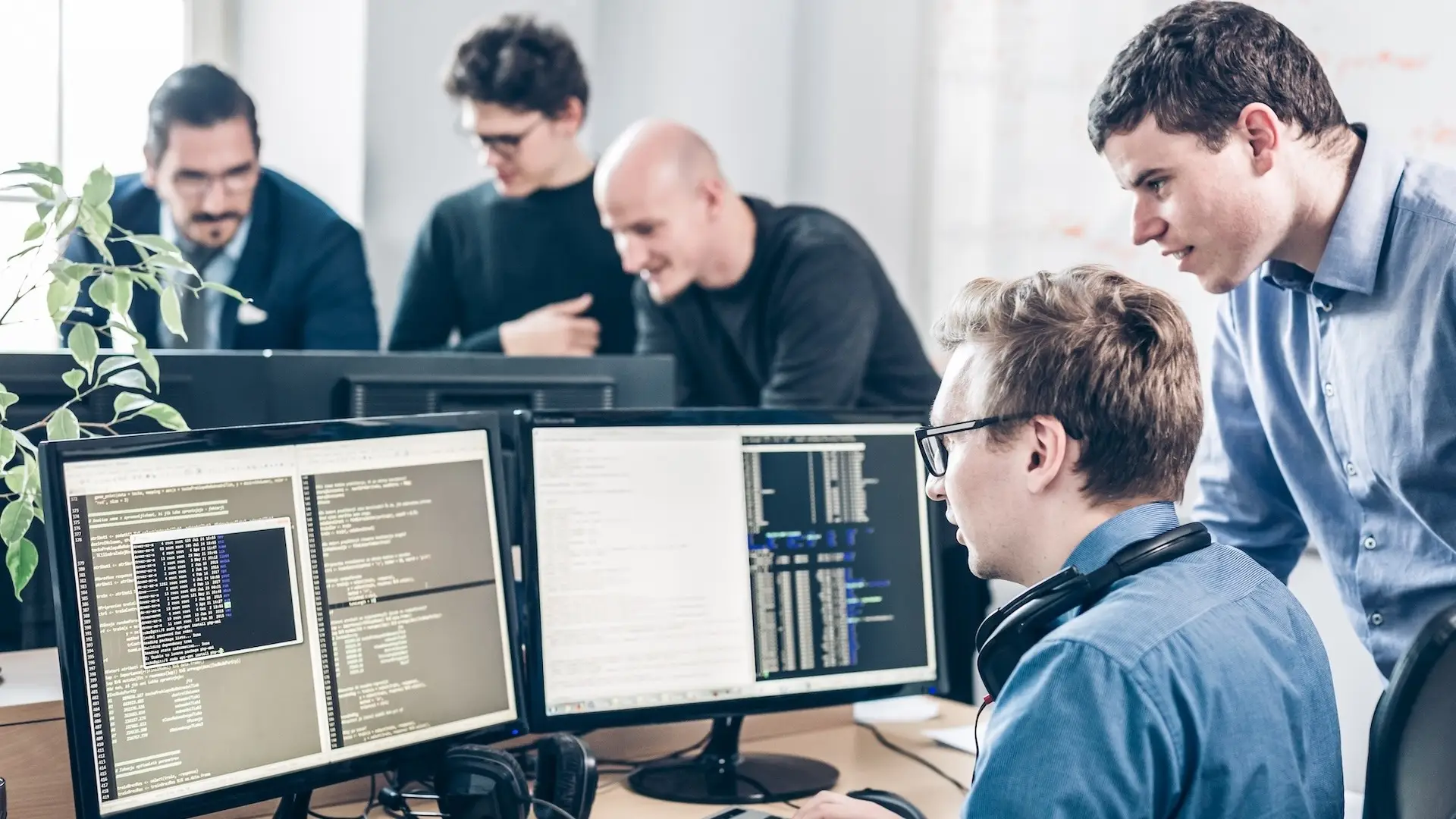 Startup business problem solving. Software developers working on desktop computer. Startup business and entrepreneurship problem solving. Young AI programmers and IT software developers team brainstorming and programming on desktop computer in startup company share office space.