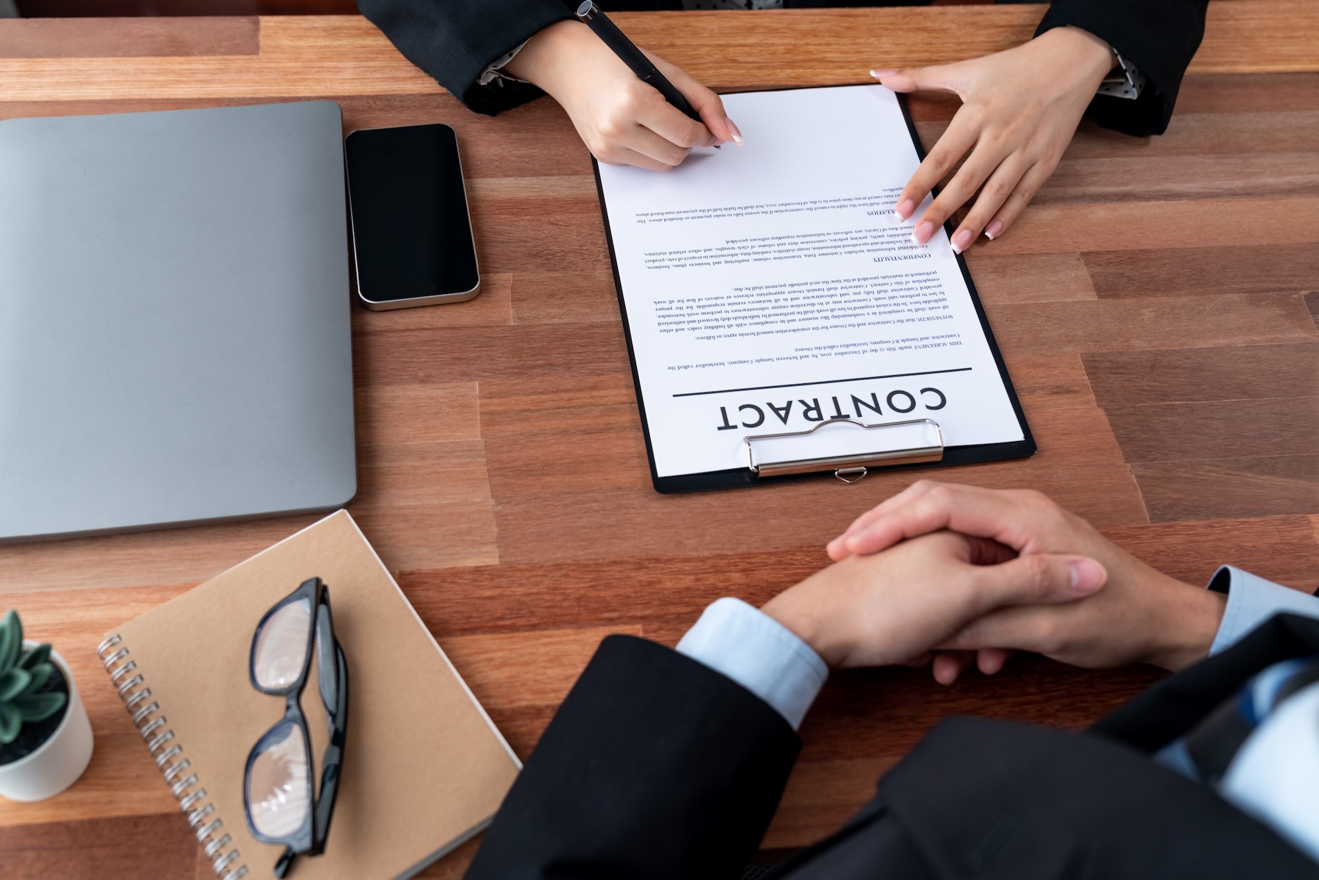 Executives sign contract in meeting room. Business people seal deal on paper. Successful agreement between two business partnership with signature signed on legal document. Jubilant